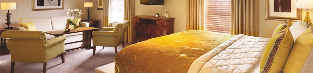 A picture of a beautiful hotel room decorated in creams and golds, at the Arden Hotel.